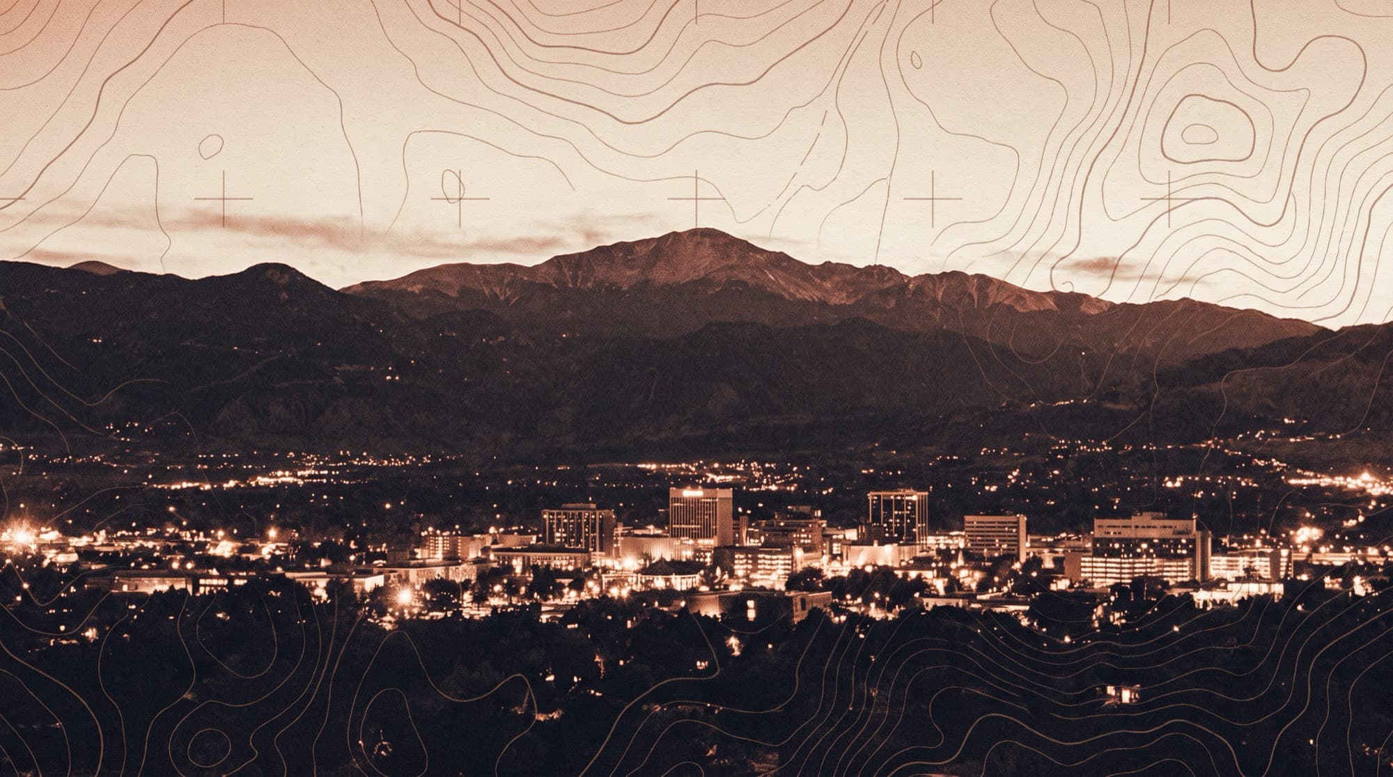 Downtown Colorado Springs at dusk beneath Pikes Peak